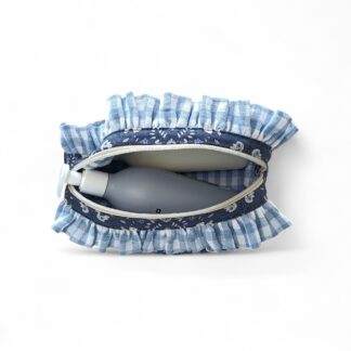 a-top-view-of-a-dark-blue-max-&-milo-toiletry-bag-or-cosmetic-pouch-with-a-nature-inspired-pattern-featuring-white-rabbits-flowers-and-foliage-with-a-blue-gingham-ruffle-along-a-cream-nylon-zip-showing-the-blue-gingham-lining-displayed-with-product