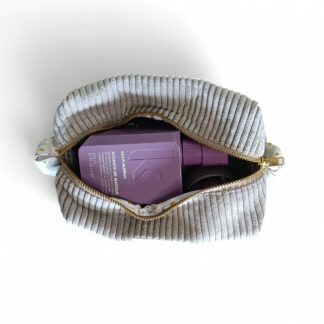 an-internal-view-of-a-max-&-milo-rectangular-makeup-or-toiletry-bag-made-of-light-gray-corduroy-and-a-brass-ykk-zipper-with-yellow-and-white-daisy-fabric-pulls-and-lining-displayed-with-product