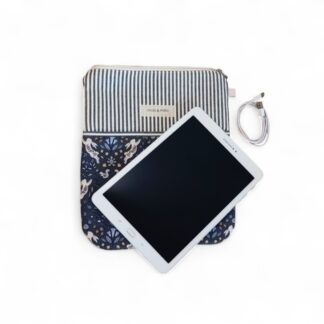 a-styled-front-view-of-a-navy-and-cream-tablet-sleeve-with-the-brand-name-max-&-milo-stitched-onto-the-front-of-the-sleeve-pictured-with-a-white-tablet-and-power-cable